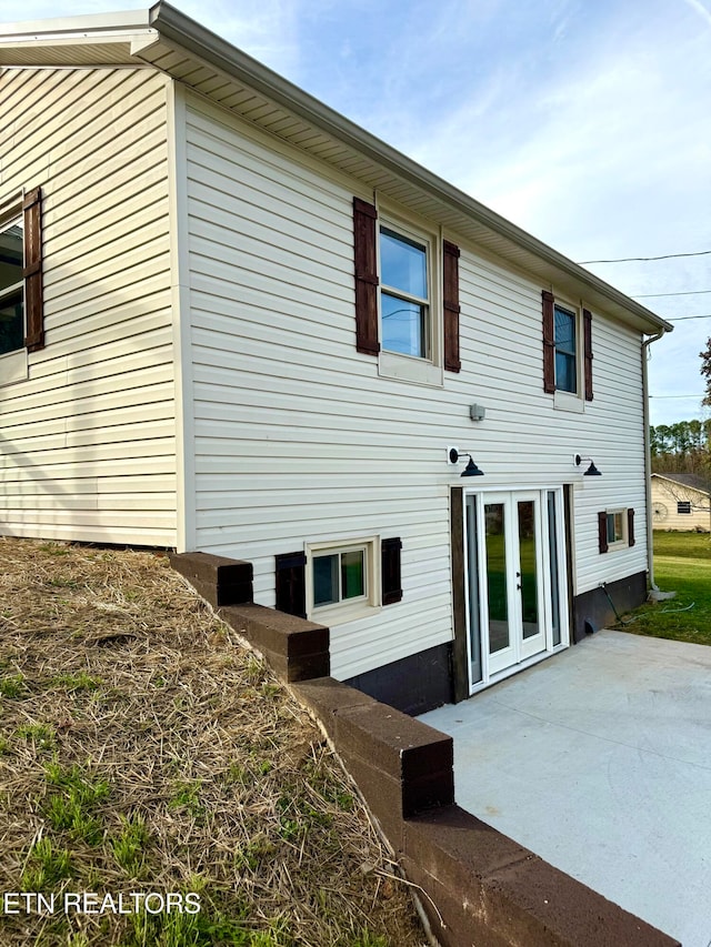 view of side of home featuring a patio and french doors