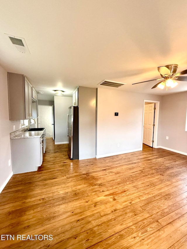 spare room featuring ceiling fan and light hardwood / wood-style flooring