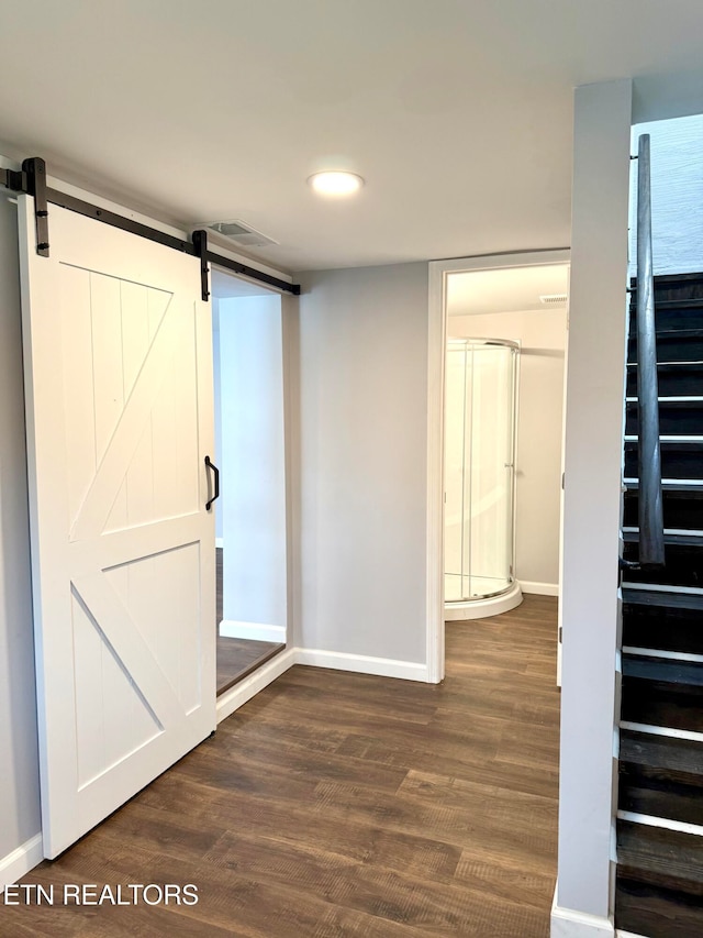 interior space featuring a barn door and dark hardwood / wood-style floors