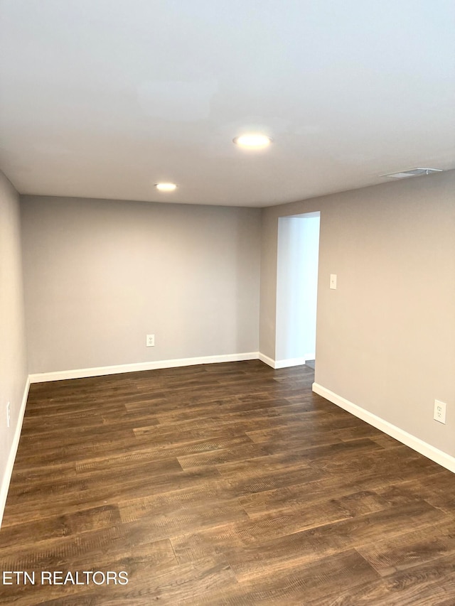 unfurnished room with dark wood-type flooring