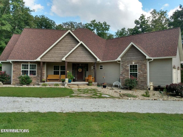 craftsman house featuring a front lawn, a porch, and a garage