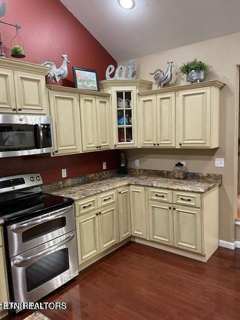 178 Woods Hill Rd, Helenwood, TN 37755 - kitchen with appliances with stainless steel finishes, cream cabinets, lofted ceiling, dark wood-type flooring, and glass insert cabinets