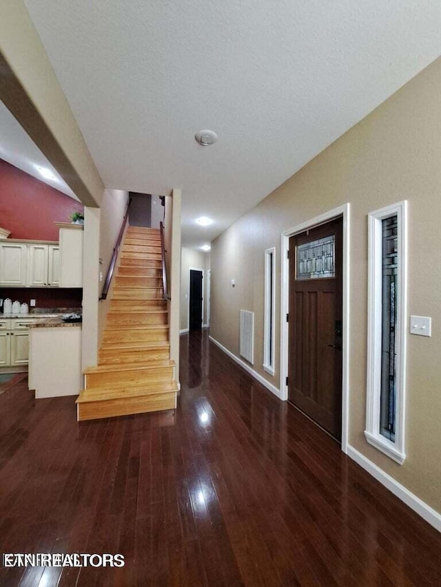 foyer with a textured ceiling and dark wood-type flooring