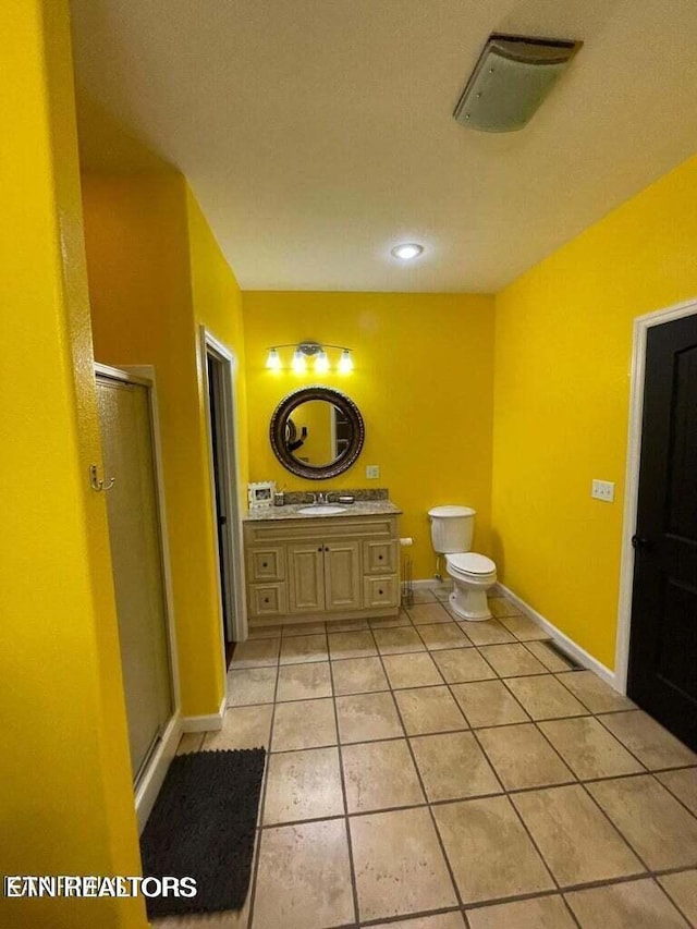 bathroom with toilet, vanity, tile patterned floors, and a shower with door