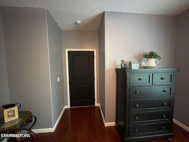 corridor with dark hardwood / wood-style flooring