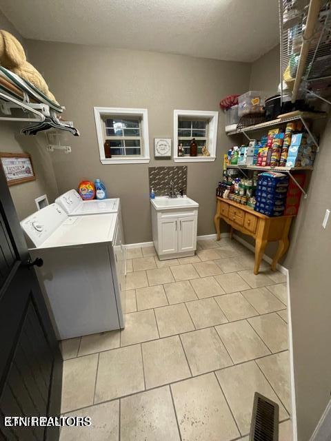 178 Woods Hill Rd, Helenwood, TN 37755 - washroom featuring washing machine and dryer, light tile patterned floors, cabinet space, and baseboards