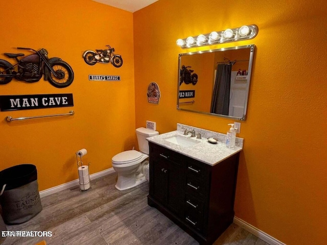 bathroom featuring a shower with shower curtain, vanity, wood-type flooring, and toilet