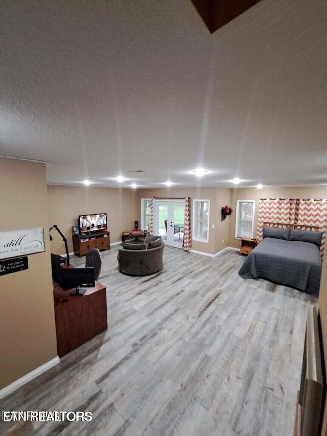 bedroom featuring wood-type flooring, a textured ceiling, and french doors