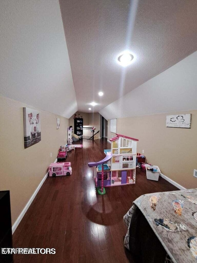 bedroom featuring a textured ceiling, dark hardwood / wood-style floors, and vaulted ceiling