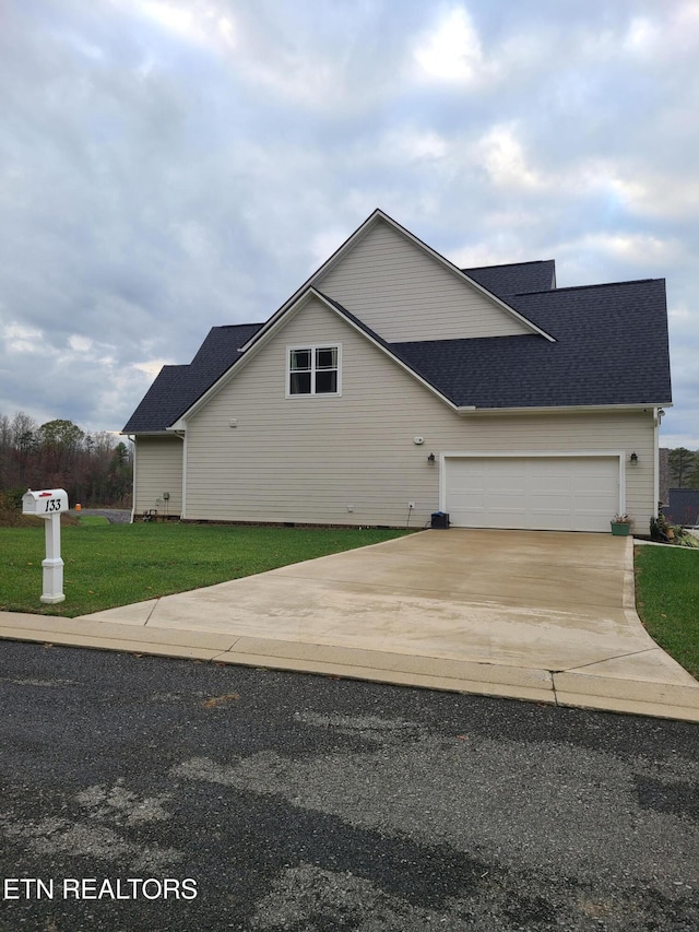 view of front of house with driveway, an attached garage, a front lawn, and a shingled roof