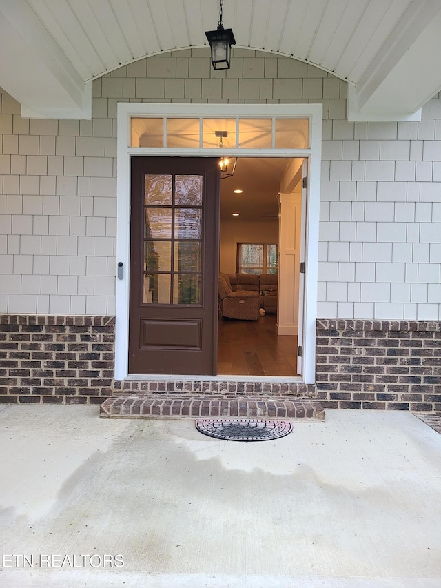 view of exterior entry with brick siding