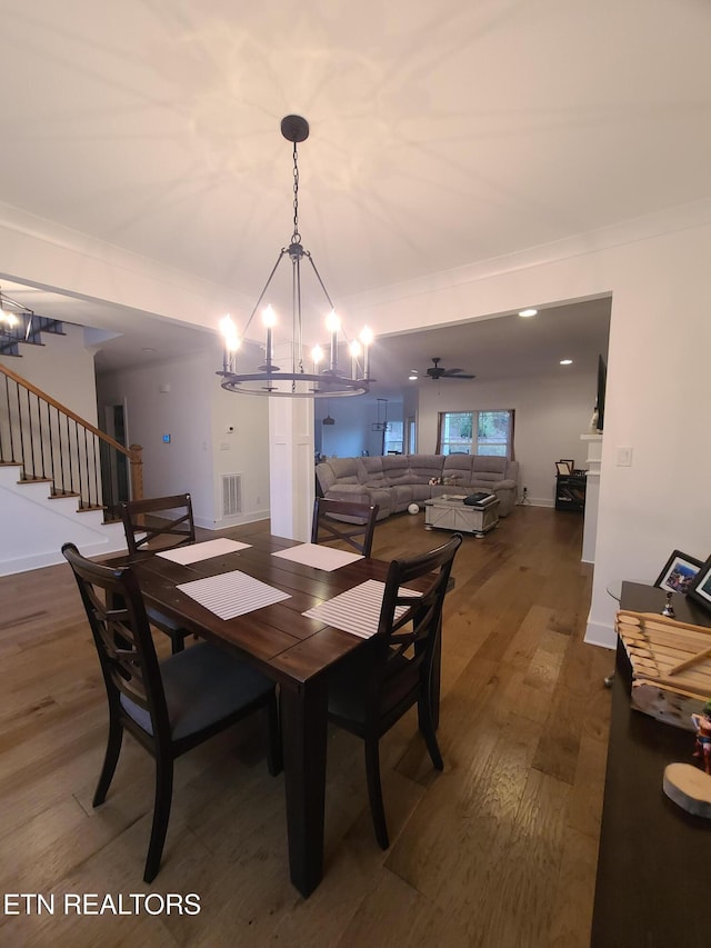 dining area with visible vents, dark wood-style floors, crown molding, baseboards, and stairs