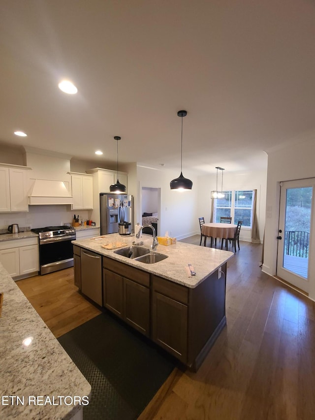 kitchen with a sink, dark wood finished floors, white cabinetry, and stainless steel appliances