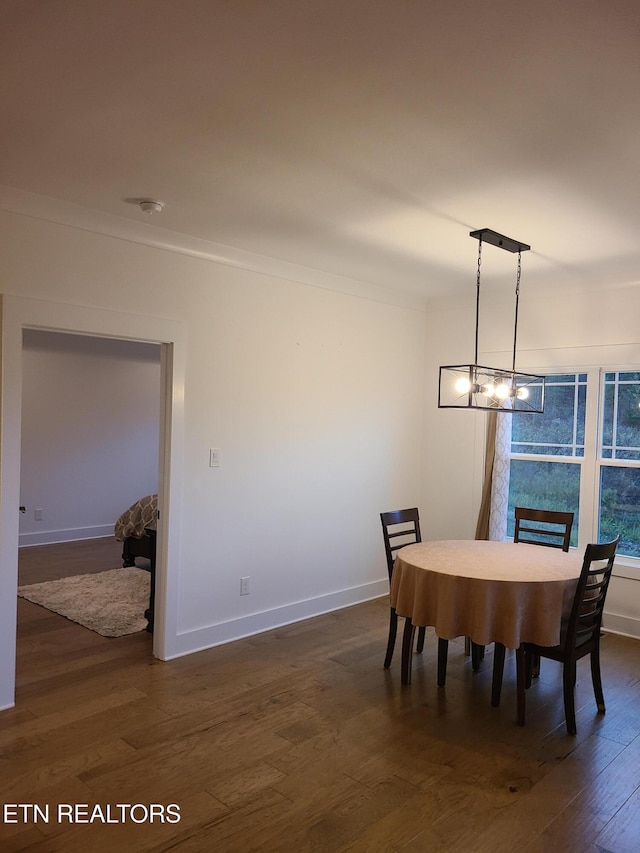 dining area featuring a fireplace, dark wood-type flooring, crown molding, and baseboards