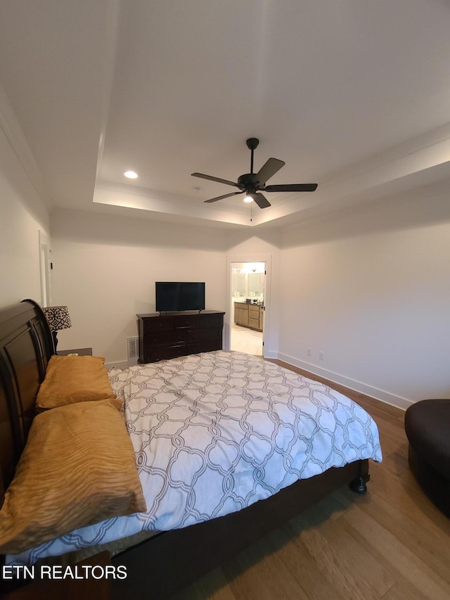 bedroom with baseboards, a tray ceiling, recessed lighting, wood finished floors, and a ceiling fan