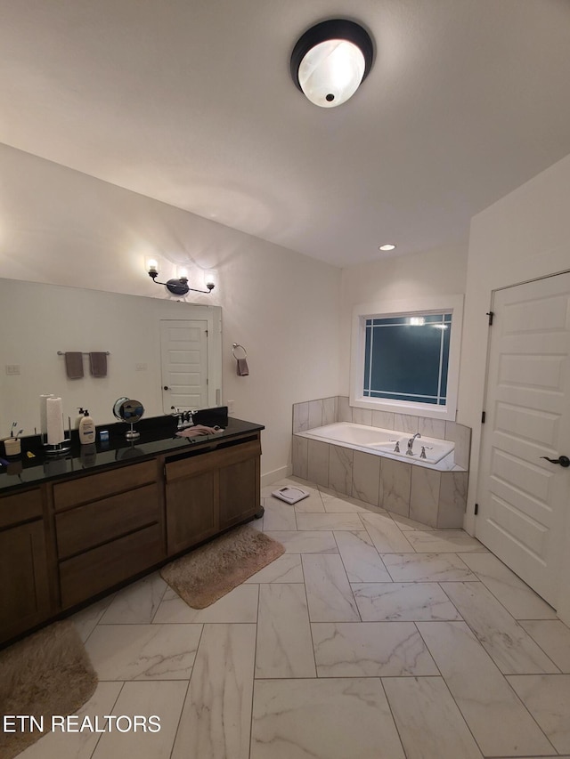 bathroom featuring vanity, a garden tub, and marble finish floor