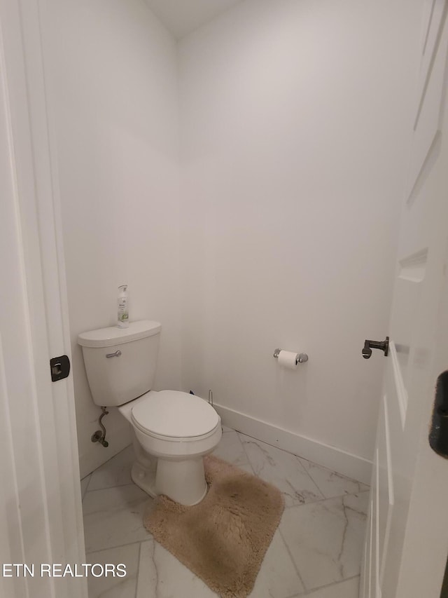 bathroom featuring marble finish floor, toilet, and baseboards