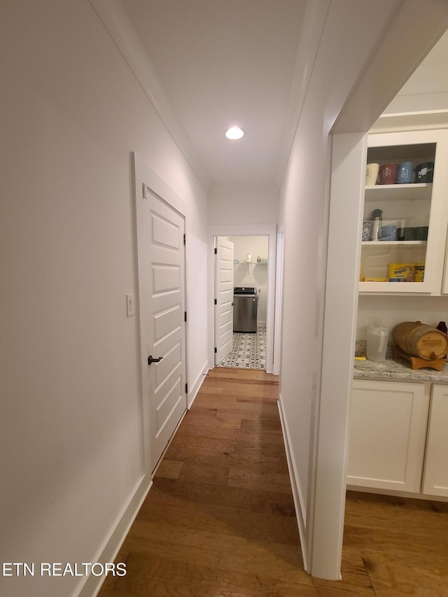 corridor with dark wood-type flooring, recessed lighting, and baseboards