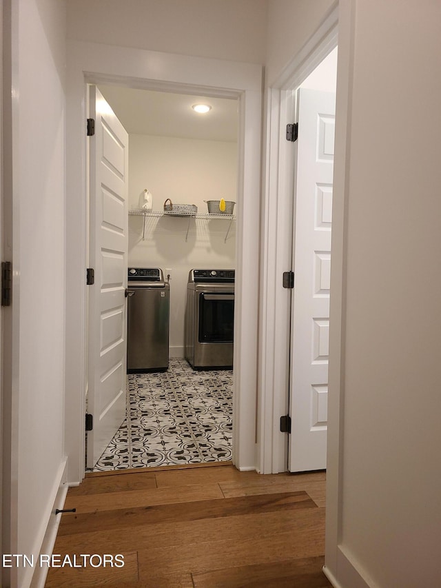 hall with separate washer and dryer and light wood finished floors