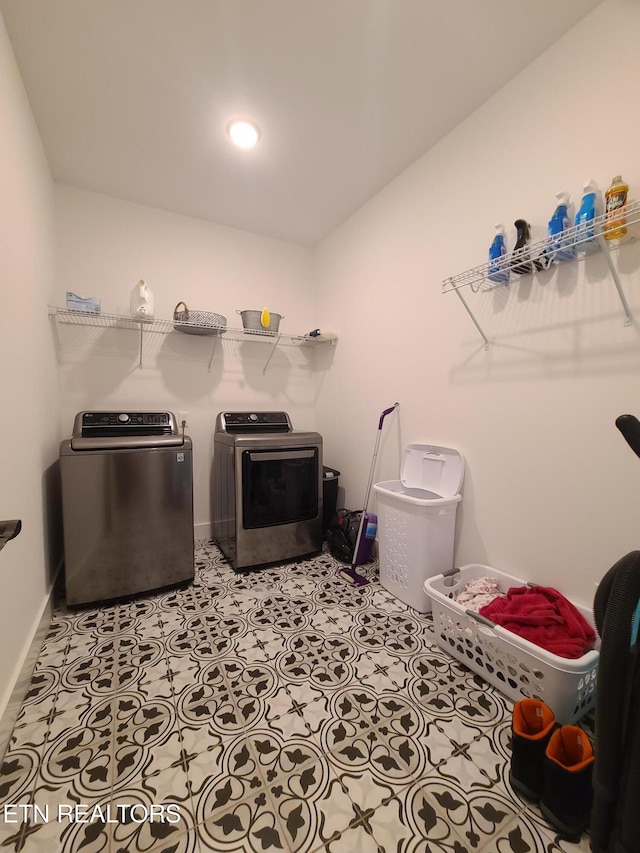 laundry room featuring tile patterned flooring, laundry area, separate washer and dryer, and baseboards