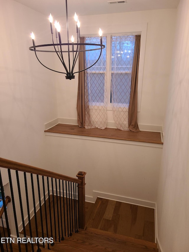 stairs featuring visible vents, baseboards, and wood finished floors