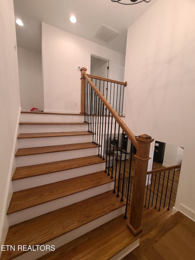 stairs with recessed lighting, wood finished floors, and visible vents