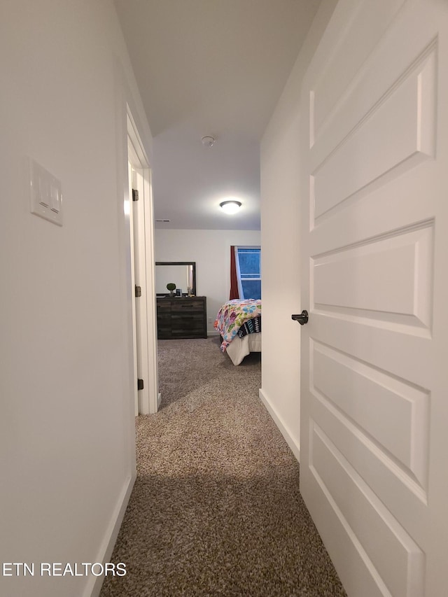 hallway with carpet flooring and baseboards