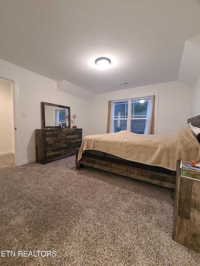 bedroom with visible vents, baseboards, carpet, and vaulted ceiling