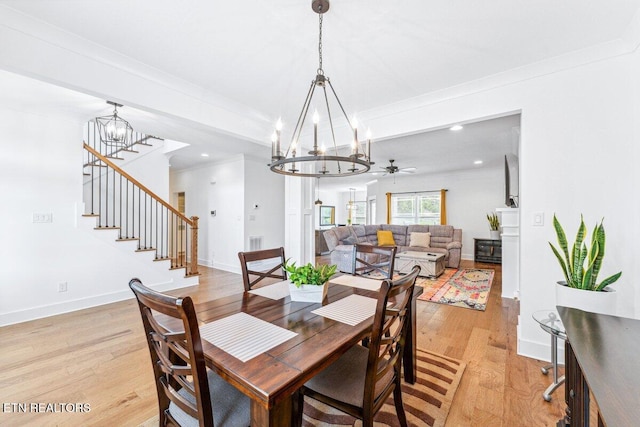 dining space featuring ornamental molding, light wood-style flooring, and a notable chandelier