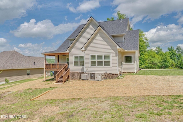 back of house with central air condition unit, roof with shingles, a deck, stairs, and a yard