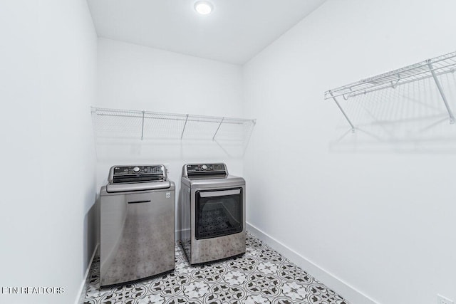 washroom with laundry area, washer and clothes dryer, and baseboards