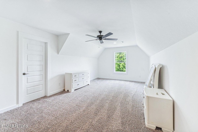 additional living space with vaulted ceiling, carpet, baseboards, and a ceiling fan