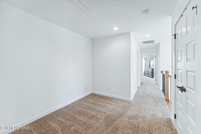 empty room featuring recessed lighting, attic access, baseboards, visible vents, and light carpet
