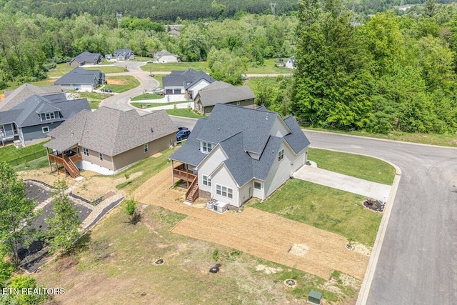drone / aerial view featuring a residential view and a view of trees