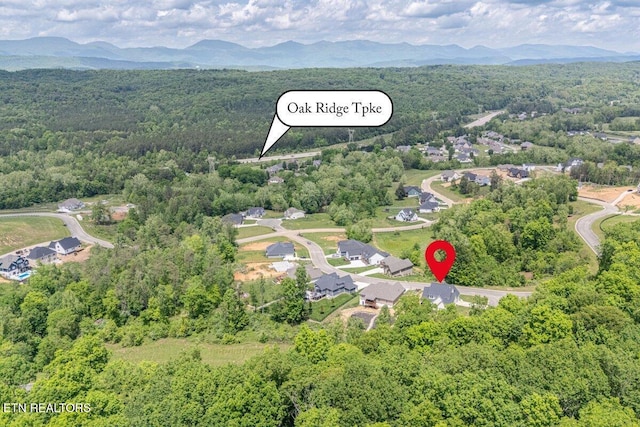 birds eye view of property with a view of trees and a mountain view
