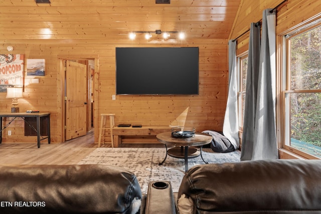 living room with light hardwood / wood-style floors, vaulted ceiling, wooden walls, and wood ceiling