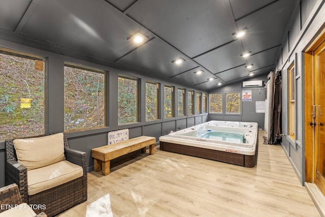 sunroom / solarium with a jacuzzi, an AC wall unit, and lofted ceiling