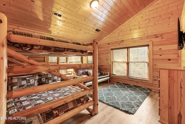 bedroom with hardwood / wood-style flooring, wooden ceiling, wooden walls, and multiple windows