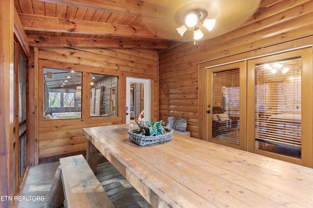 dining area featuring ceiling fan, wooden ceiling, lofted ceiling with beams, wooden walls, and hardwood / wood-style flooring