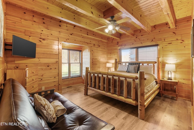 bedroom featuring wood-type flooring, multiple windows, and wood walls