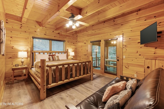 bedroom with multiple windows, hardwood / wood-style floors, and beamed ceiling