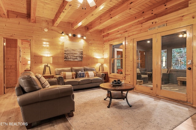 living room featuring beamed ceiling, light hardwood / wood-style floors, wooden ceiling, and wooden walls