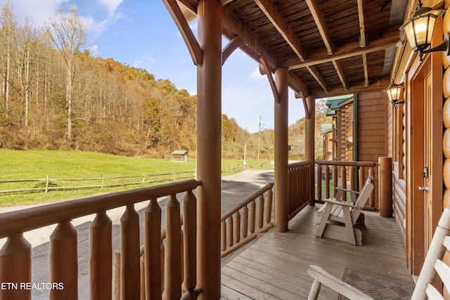 wooden deck with covered porch and a lawn