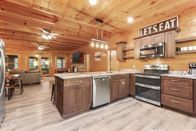 315 Caney Creek Rd, Pigeon Forge, TN 37863 - kitchen featuring open shelves, stainless steel appliances, open floor plan, a peninsula, and a sink