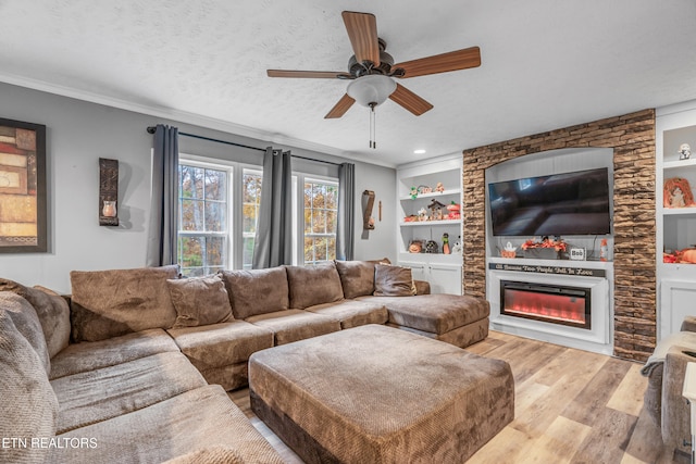 living room featuring built in shelves, a textured ceiling, light hardwood / wood-style flooring, and ceiling fan