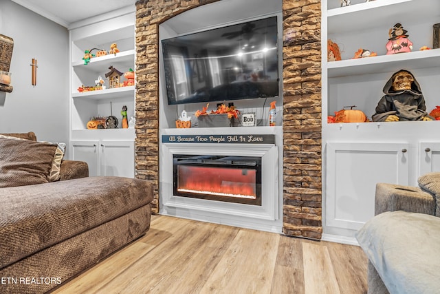 living room with built in features, ornamental molding, and hardwood / wood-style flooring