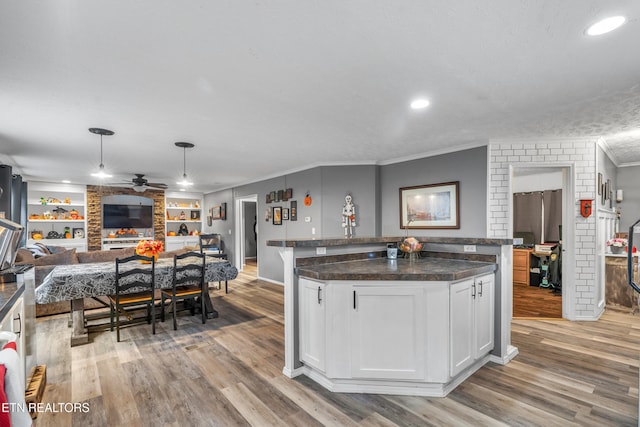 kitchen with white cabinets, pendant lighting, a center island, and light hardwood / wood-style floors