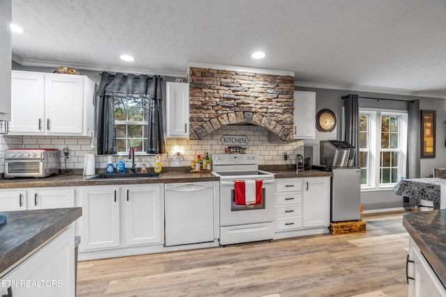 kitchen with white cabinets, light wood-type flooring, white appliances, and sink