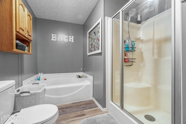 bathroom with hardwood / wood-style floors, independent shower and bath, a textured ceiling, and toilet