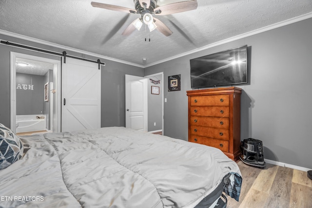 bedroom with ceiling fan, a barn door, crown molding, a textured ceiling, and light wood-type flooring